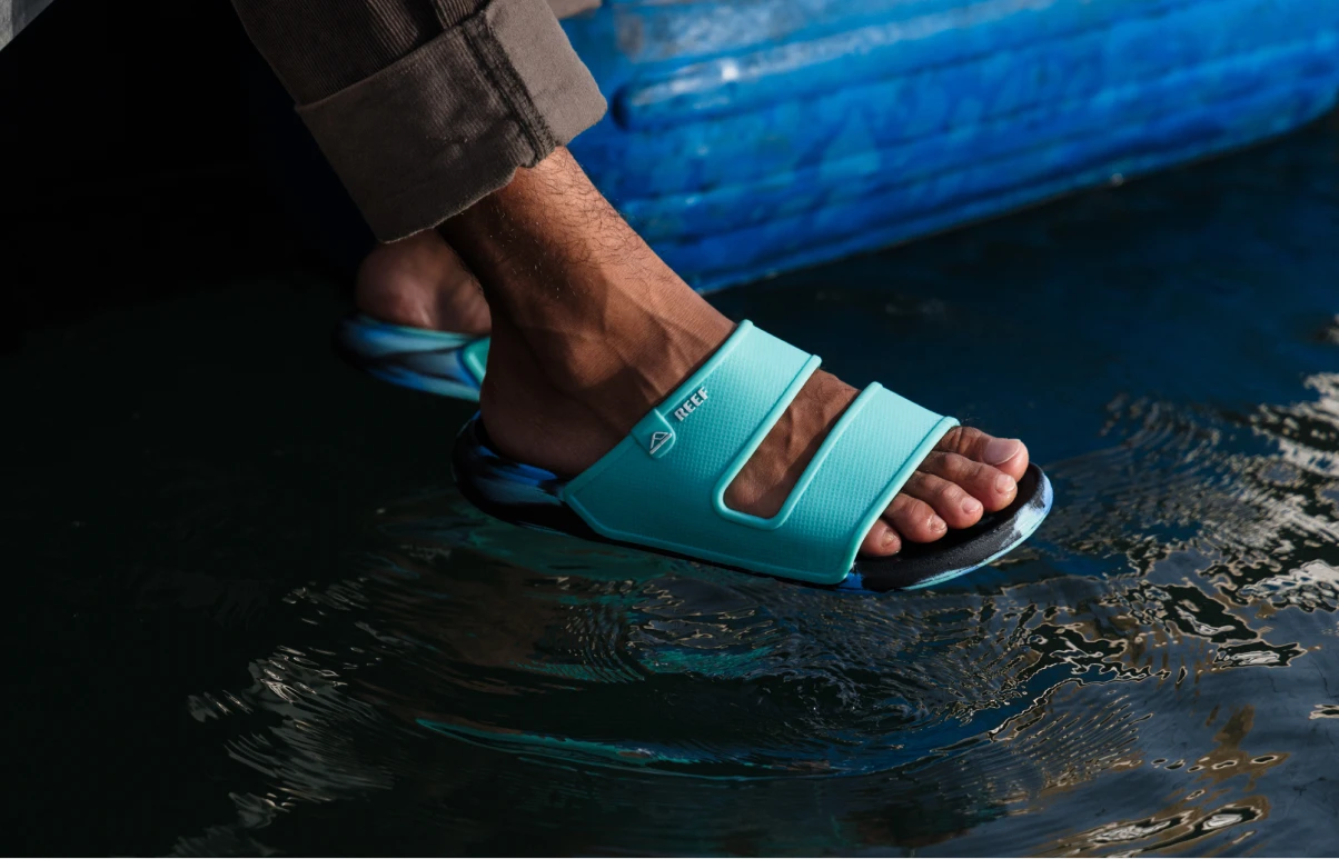 Close up of man holding Deckhand Flip Flop Sandals in hand