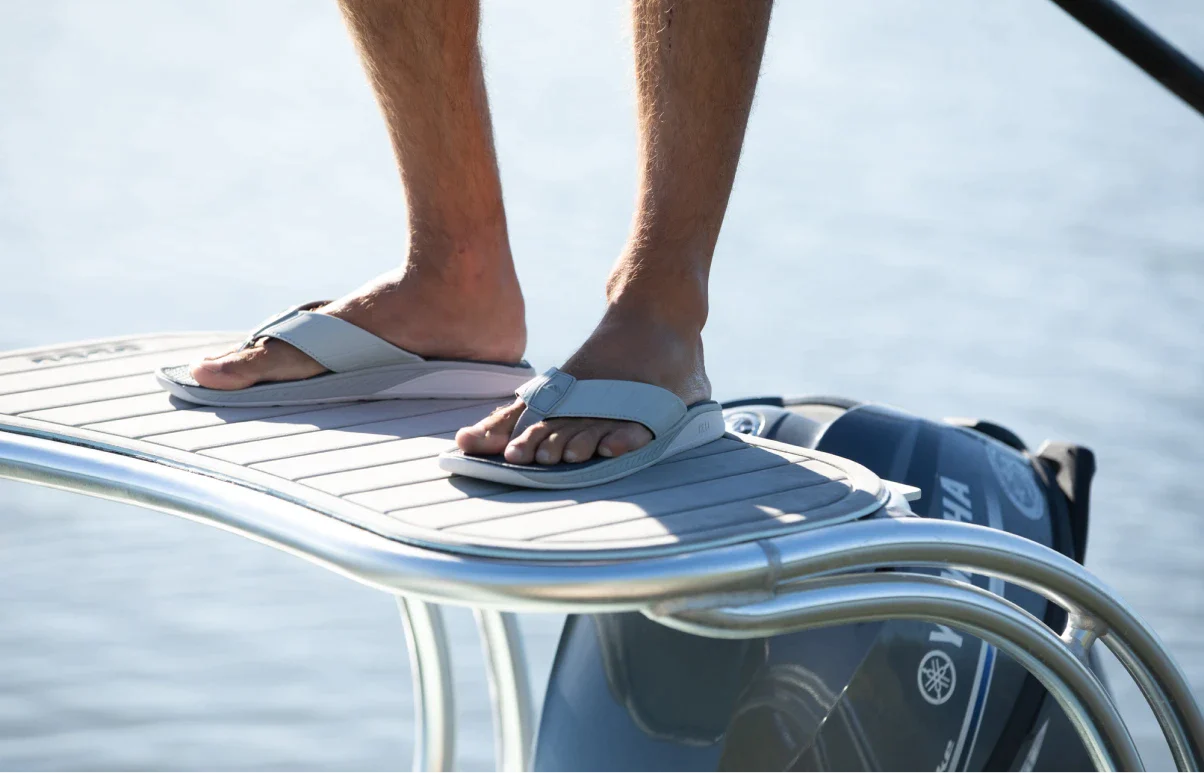 Man standing on a platform on a boat wearing the Deckhand sandal.