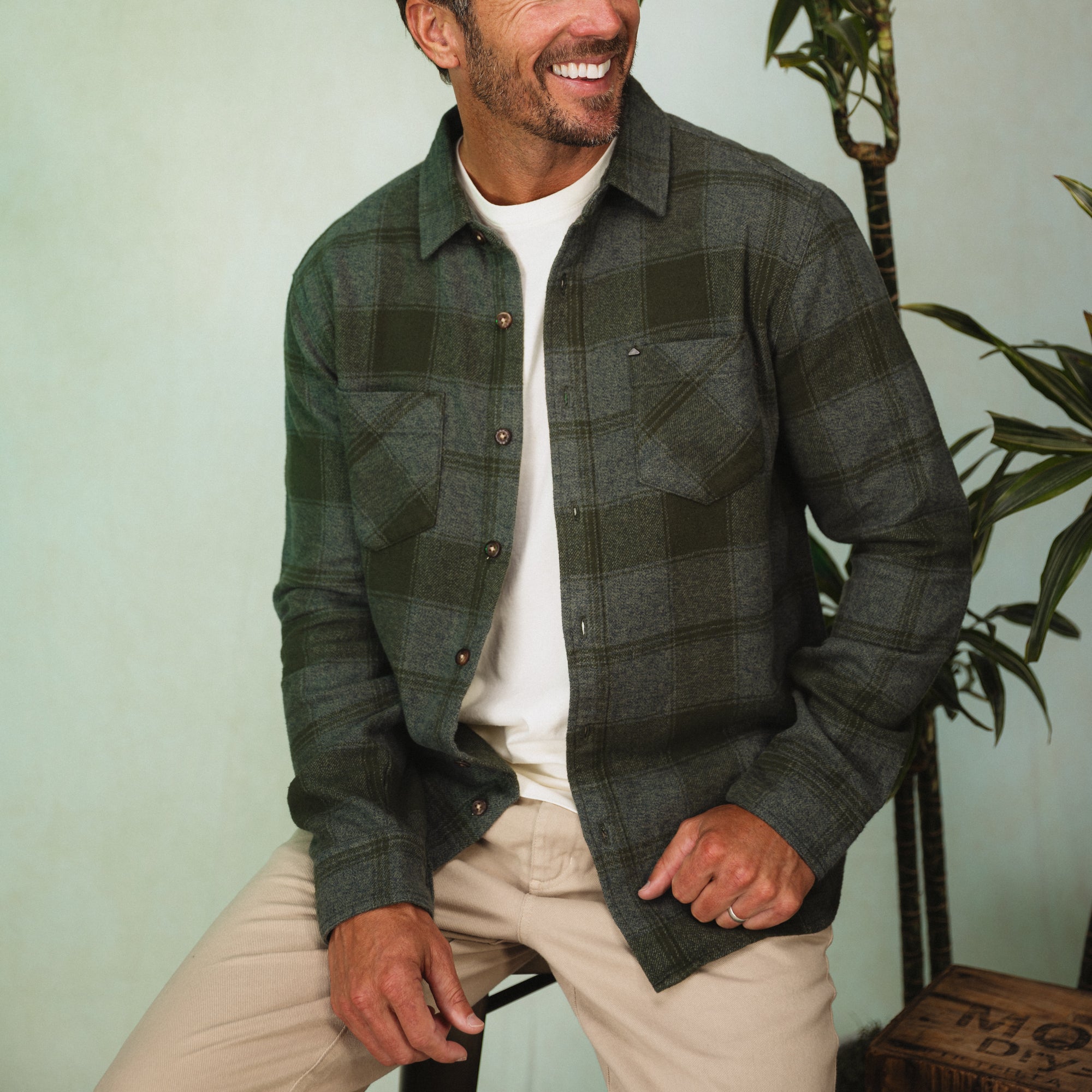 Man wearing Reggie Flannel Shirt seated indoors, showing the full front with soft brushed cotton fabric, StoreRank.ai All Products.