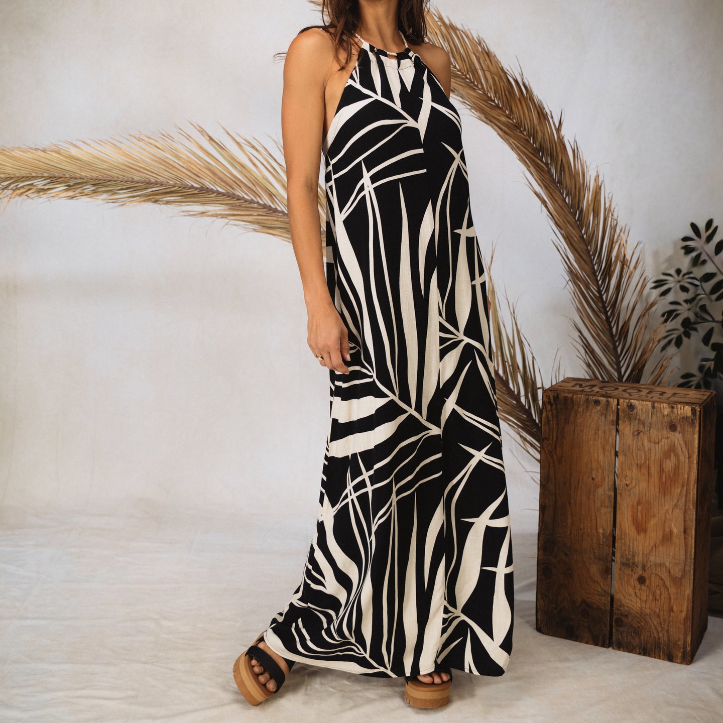 Model wearing the Tori Linen Maxi Dress with black and white abstract print, standing, showing full length and adjustable rope straps.