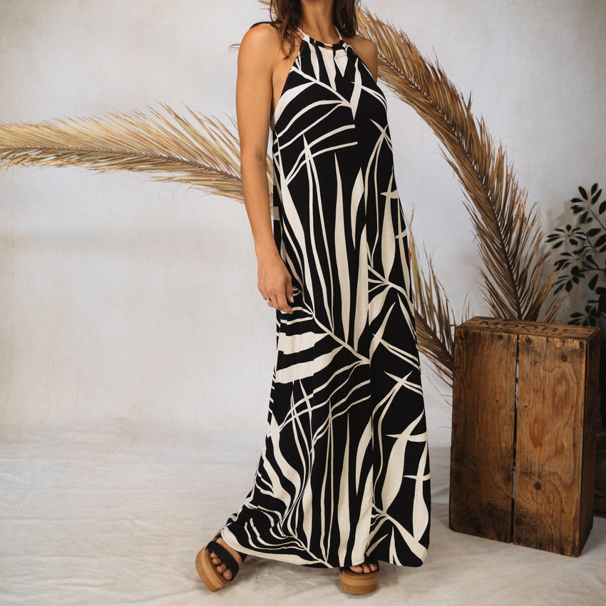 Model wearing the Tori Linen Maxi Dress with black and white abstract print, standing, showing full length and adjustable rope straps.