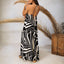 Woman wearing Tori Linen Maxi Dress with black and white print, adjustable halter straps shown from back, relaxed beach style.