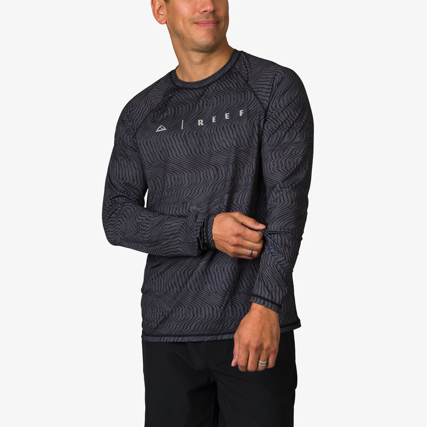 Man wearing a black patterned Dune Performance Shirt facing slightly left, showing front and left sleeve details.