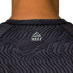 Close-up of the back neck area of the men's Dune Performance Shirt with surf-inspired dark patterned fabric and REEF logo.