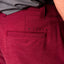 Close-up of the back pocket and logo on men's Destro Hybrid Short in burgundy, surf-inspired comfort apparel.