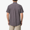 Back view of a man wearing a grey Collins Ss Wvn Shirt with short sleeves, casual fit for beach and active lifestyle.