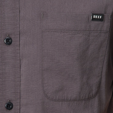 Close-up of the front pocket on the Collins Ss Wvn Shirt in gray with REEF label, designed for comfort and everyday wear.