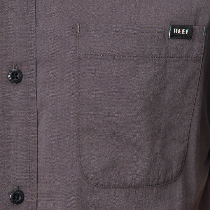 Close-up of the front pocket on the Collins Ss Wvn Shirt in gray with REEF label, designed for comfort and everyday wear.