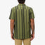 Man wearing Angelo Short Sleeve Camp Shirt in green vertical stripes, back view, casual beach-inspired apparel design.