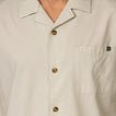 Close-up of the front chest and collar of the beige Harold Camp Shirt with tortoiseshell buttons for men’s beach apparel.