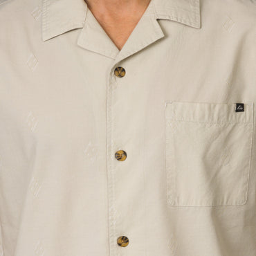 Close-up of the front chest and collar of the beige Harold Camp Shirt with tortoiseshell buttons for men’s beach apparel.