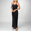 Woman wearing a black Plisse Dress with spaghetti straps and black surf-inspired sandals facing forward, full body shot.