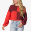 Woman wearing a red and burgundy color-block Carrie Sweater with long sleeves, shown from waist up, casual beach-inspired comfort.