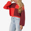 Woman wearing the Carrie Sweater, front view, with colorblock red and burgundy knit and loose sleeves.