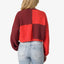 Rear view of Carrie Sweater in red and burgundy block colors, showing knit texture and relaxed fit on model.