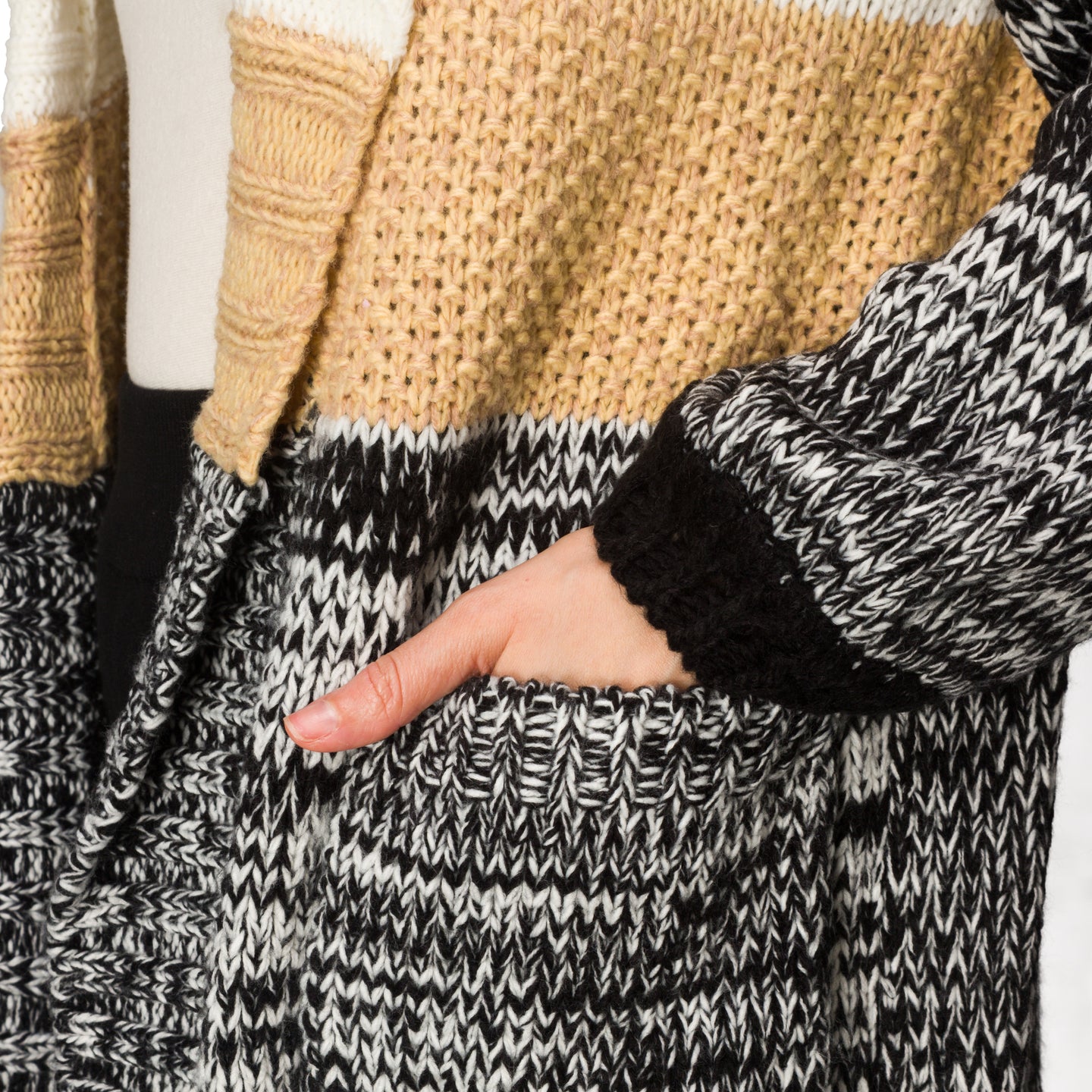 Close-up of hand in patch pocket of Hazy Sweater Cardigan showing chunky knit texture and colorblocked sleeves.