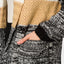 Close-up of hand in patch pocket of Hazy Sweater Cardigan showing chunky knit texture and colorblocked sleeves.