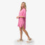Woman wearing a pink Ollie Shirt Dress walking in beige REEF slides with anatomical arch support facing right side.