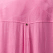 Close-up of pink Ollie Shirt Dress fabric showing textured leaf pattern and small metal logo detail on the back panel.