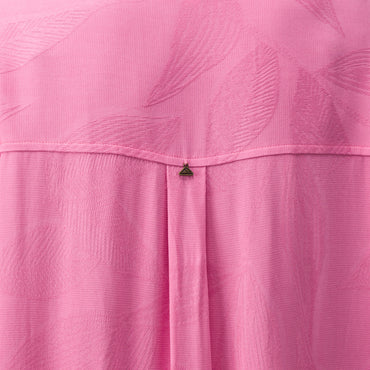 Close-up of pink Ollie Shirt Dress fabric showing textured leaf pattern and small metal logo detail on the back panel.
