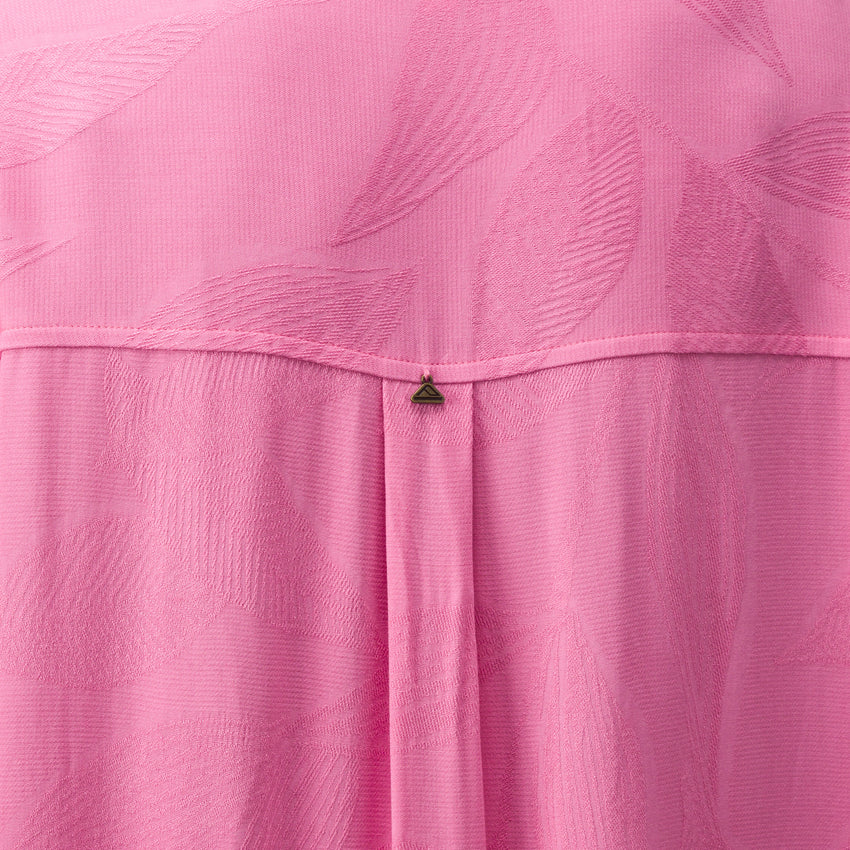 Close-up of pink Ollie Shirt Dress fabric showing textured leaf pattern and small metal logo detail on the back panel.