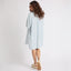 Woman wearing Ollie Striped Shirt Dress viewed from back, walking, showing comfort-focused footwear facing right side.