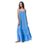 Woman wearing a blue Lainey Maxi Dress with thin straps paired with tan sandals facing left in a full-length shot