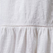 Close-up of white Yuni Maxi Dress fabric showing textured eyelet and delicate stitching details.