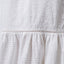 Close-up of white Yuni Maxi Dress fabric showing textured eyelet and delicate stitching details.