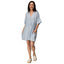 Woman wearing light blue Lainey Shirt Dress with buttons, side pockets, and slip-on shoes facing forward, beach-inspired comfort apparel.