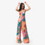 Woman wearing Eve Wide Leg Romper with colorful floral print, standing and smiling in a relaxed pose.