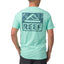 Man wearing light blue Wellie Too Tee facing away showing back logo, casual surf-inspired apparel for the beach.