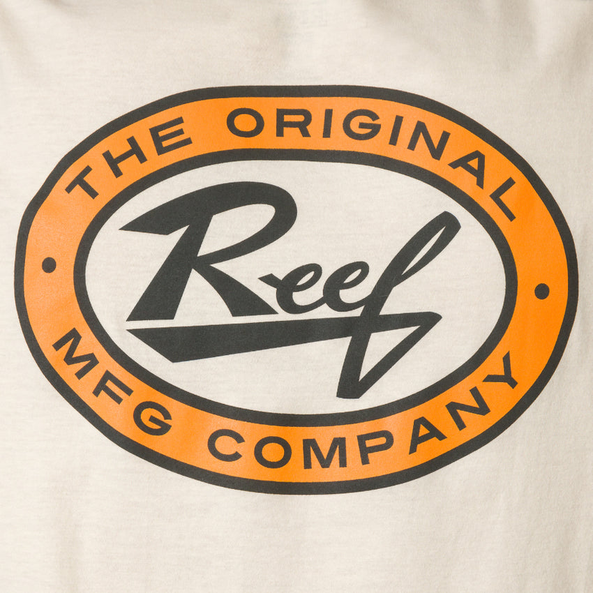 Close-up of the chest logo on the cream Auto Tee, featuring bold orange and black Reef branding, beach-inspired style.