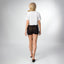 Woman wearing Night Surf Crop Crew Tee, shown from the back, walking in black REEF sandals facing away from the camera.