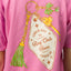 Close-up of the pink Haus Boyfriend Crew shirt back featuring a colorful surf-inspired keychain graphic with palm tree and tassel.
