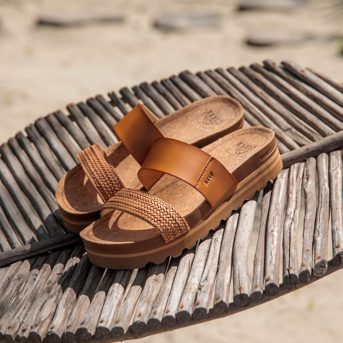 Cushion vista Hi platform sandal in natural braid on the beach on wooden plate