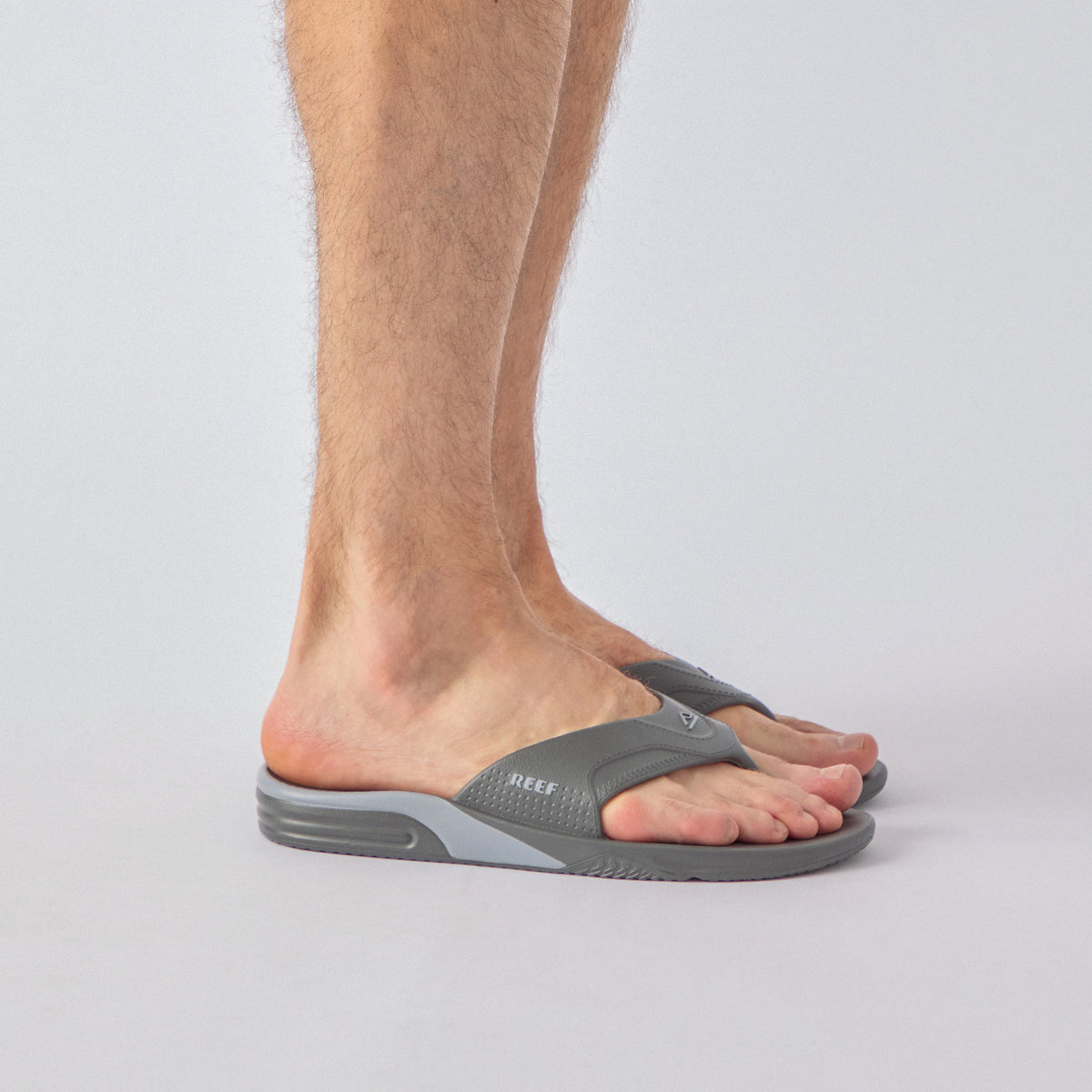 Fanning H2O gray water friendly flip flops facing right in side view on a person’s foot