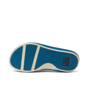 Cruiser men’s shoe sole facing up, showing blue rubber outsole with wave pattern and brand logo, surf-inspired comfort design.