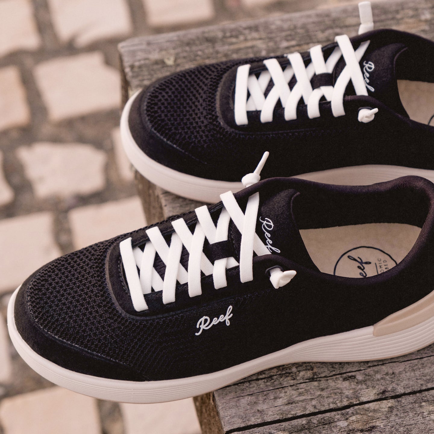 Shoreline Palisades black sneakers facing right, close-up of upper and laces, beach-inspired comfort and support.