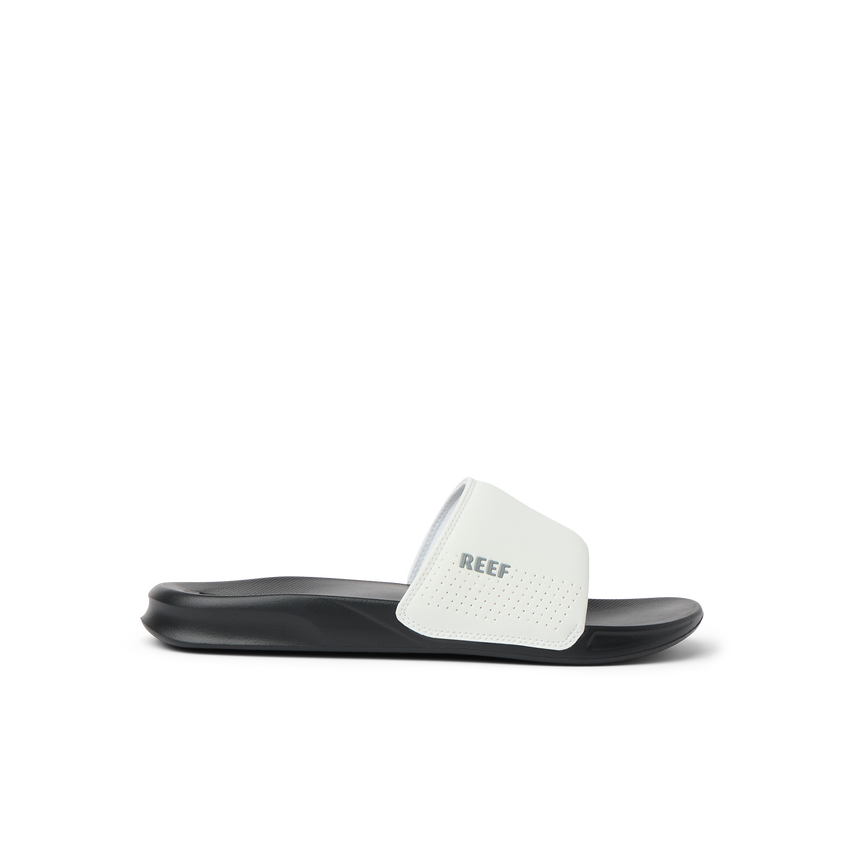 Side view of a black and white Reef One Slide sandal, water friendly and designed for beach comfort and support.