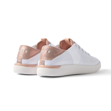 Reef Neptune women's white shoe with rose gold heel counter facing backward, showcasing cushioned, breathable design.