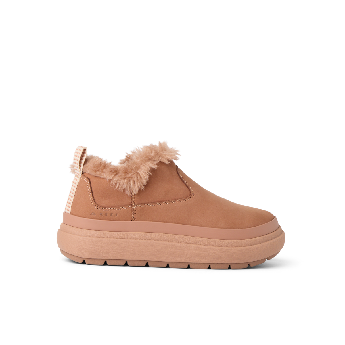 Side view of a tan slip-on shoe facing right with plush lining and thick cushioned sole for beach comfort.