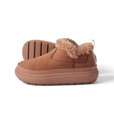 Side view of tan slip-on shoe with plush collar, thick cushioning sole, and durable outsole facing left