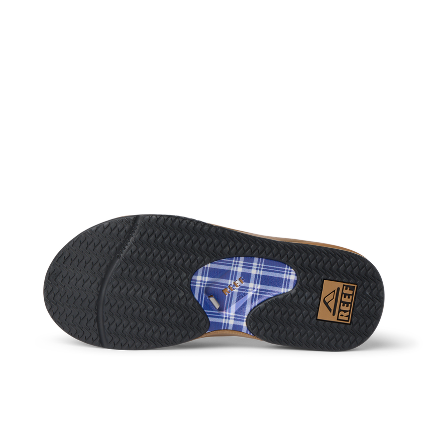 Bottom sole view of the Fanning sandal showing textured grip, plaid arch support, and REEF branding in black and tan colors.