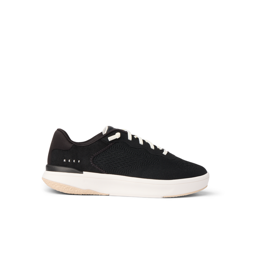 Side view of black Reef Del Mar sneaker with white sole, lightweight and cushioned for beach and everyday comfort.