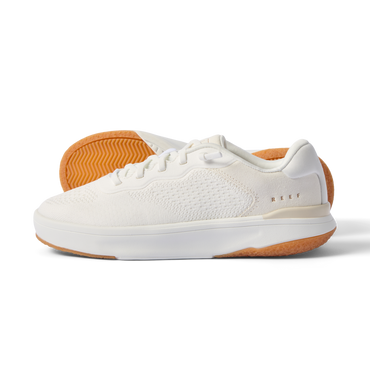 Side view of Reef Del Mar white sneaker with textured breathable upper and tan rubber sole showing grip pattern.