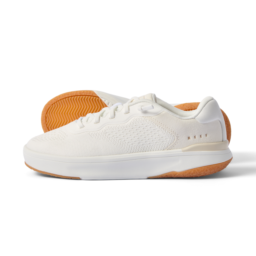 Side view of Reef Del Mar white sneaker with textured breathable upper and tan rubber sole showing grip pattern.