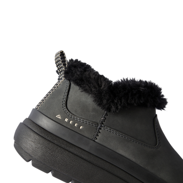 Close-up of the left side of the Weekend Olivia boot in black with plush lining, water-resistant nubuck, and REEF logo.
