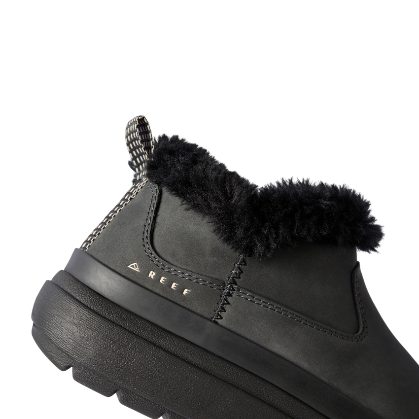 Close-up of the left side of the Weekend Olivia boot in black with plush lining, water-resistant nubuck, and REEF logo.