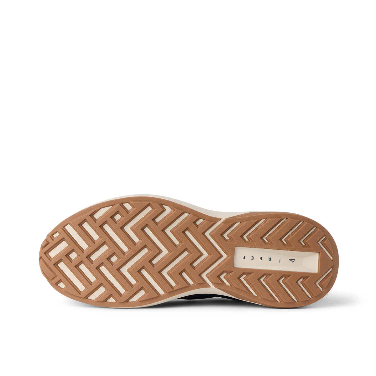 Reef Zuma sneaker close-up, outsole facing up with toe pointing left and heel right, showing textured tread and cushioned sole